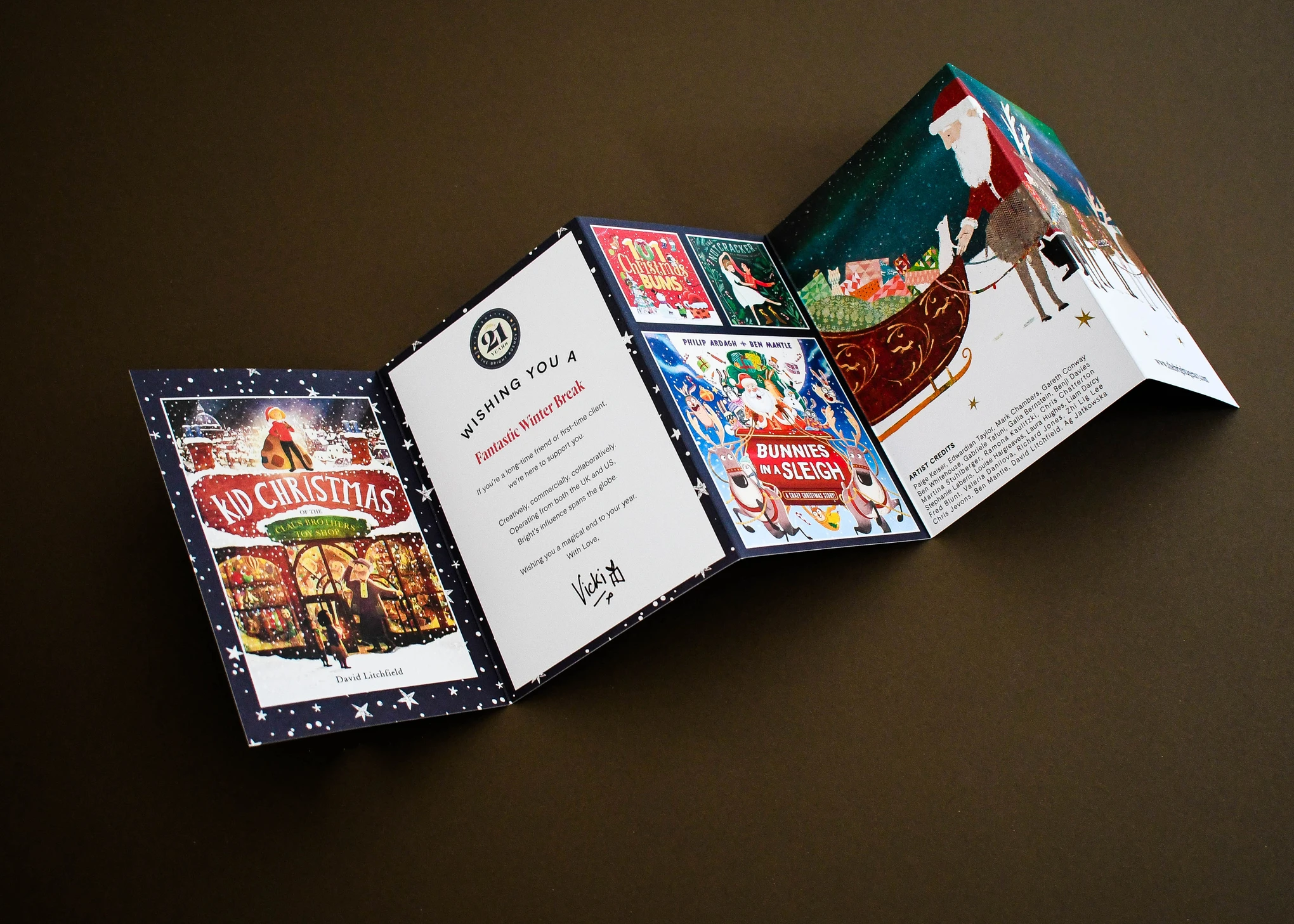Concertina-folded Christmas card opened out to show all five panels and artist credits.