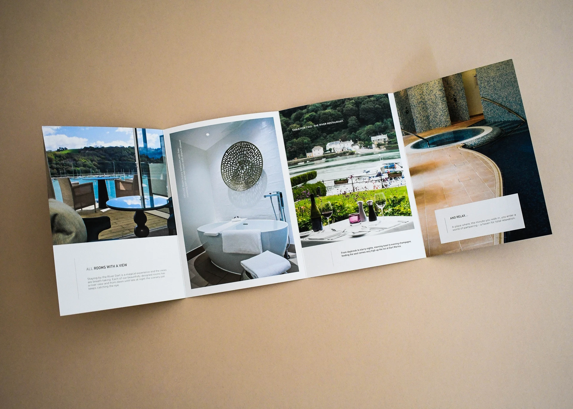 A four-panel fold-out hotel brochure opened flat, showing rooms, restaurant and spa photography.