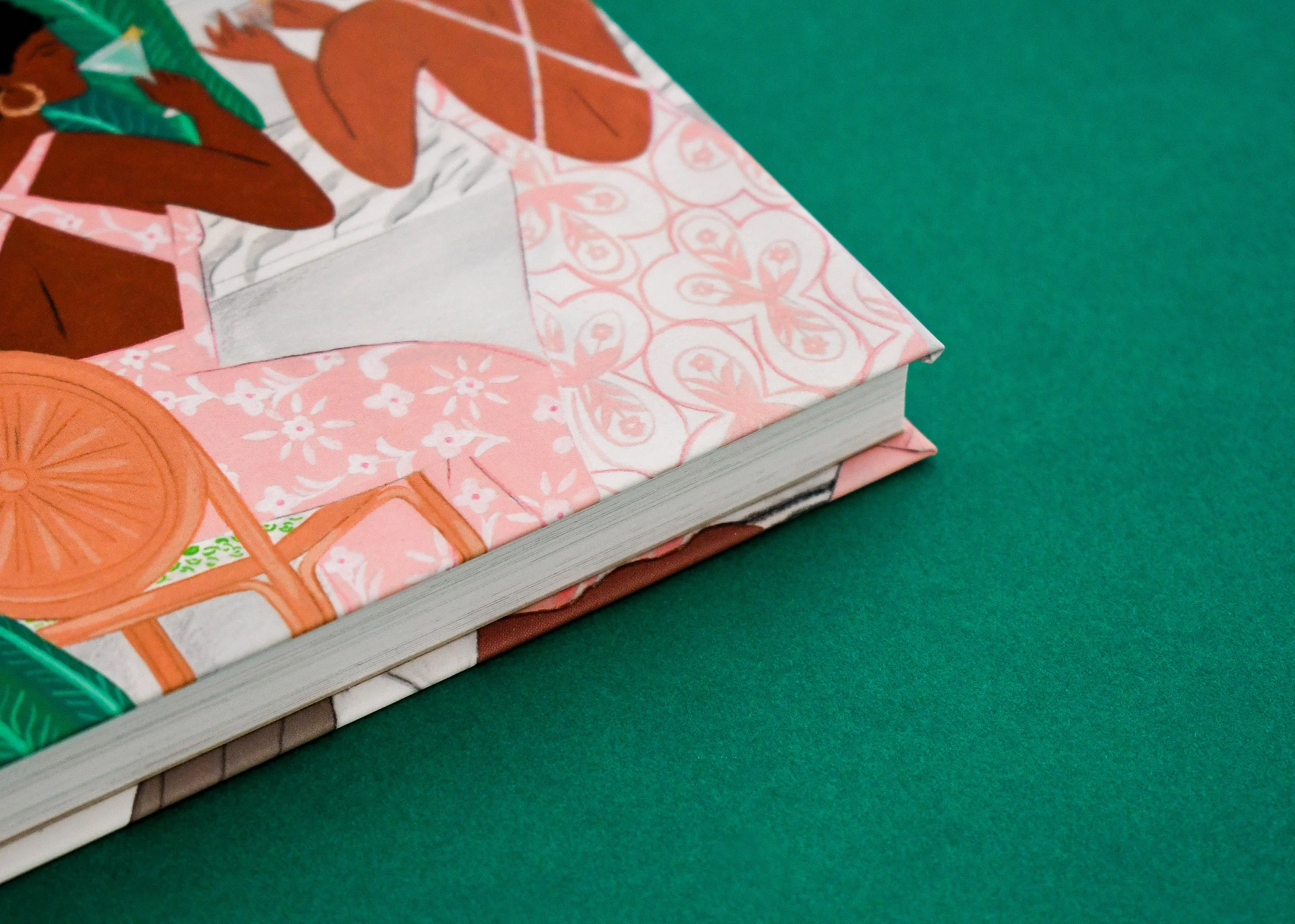 Corner of an illustrated hardback, the printed cover wrapping the board above the page block.