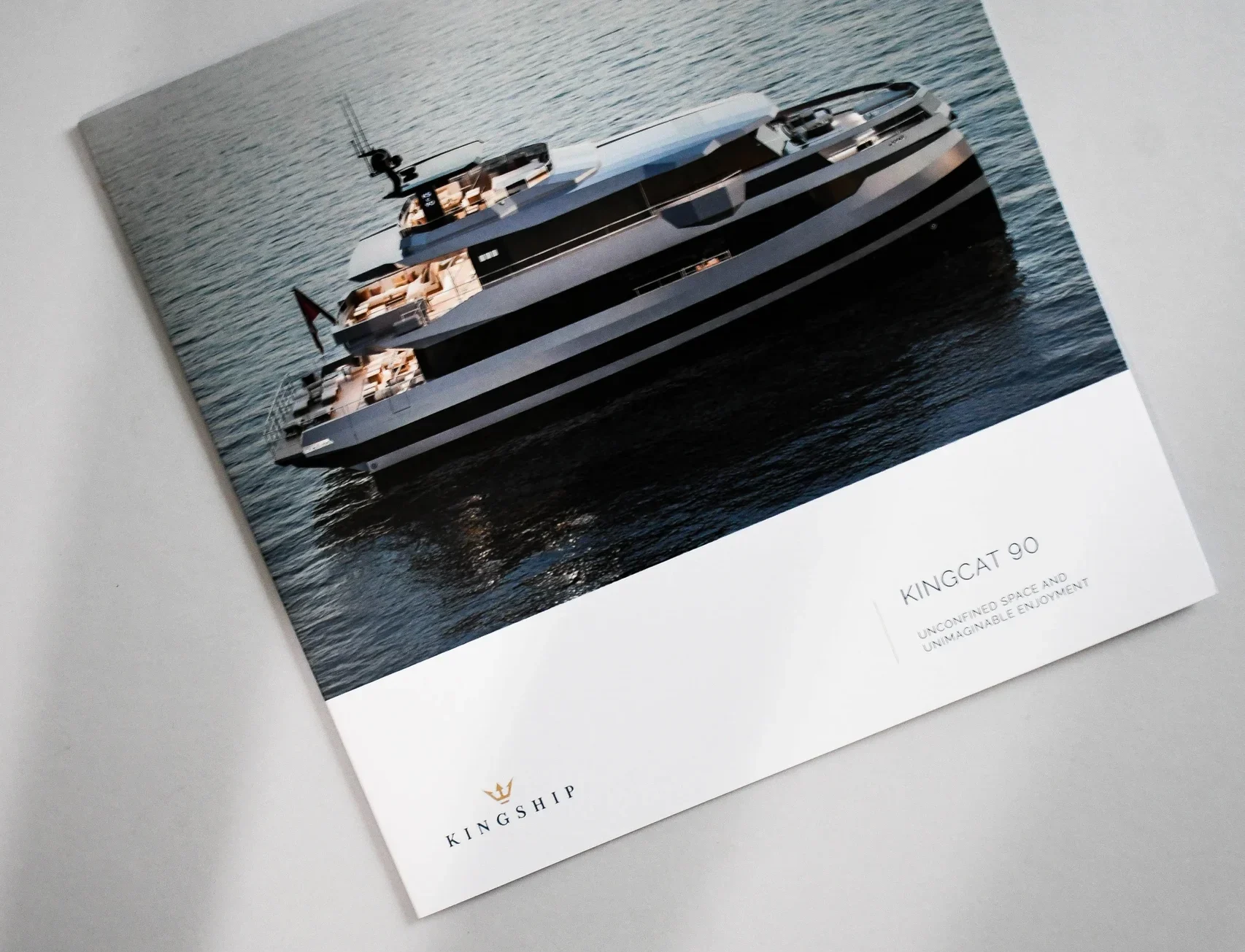 Premium printed yacht brochure featuring a luxury catamaran with high quality photographic reproduction and crisp print finish.
