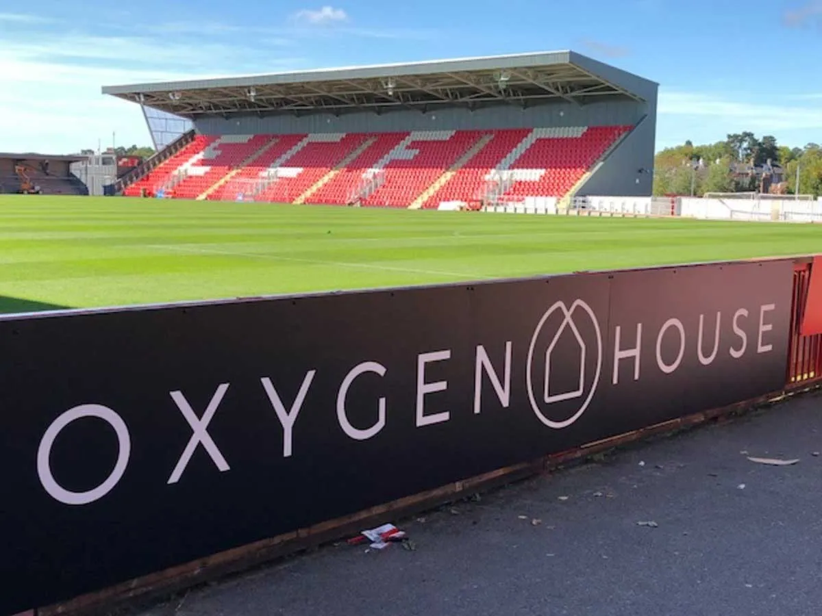 Close up of pitch side advertising boards for sponsors running along the touchline at a football ground.
