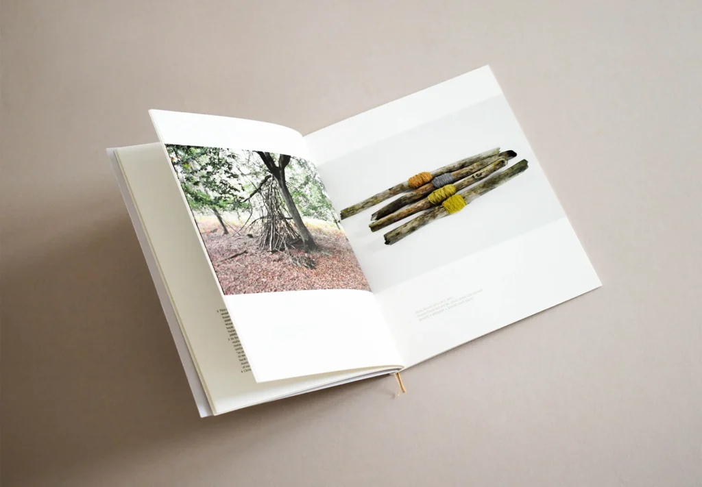 A central page spread of a brochure featuring a bookmark ribbon and bespoke yellow stitching on the spine, adding a unique and elegant touch to its design.