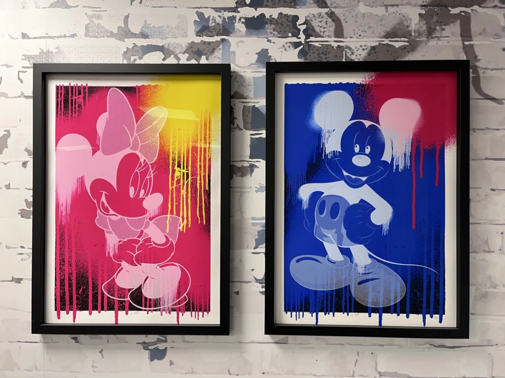 Two art prints of Mini Mouse hung on a wall.