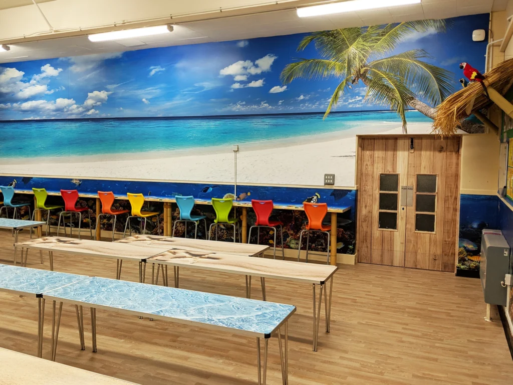 Large wall graphic of a sunny beach on a School Canteen wall.