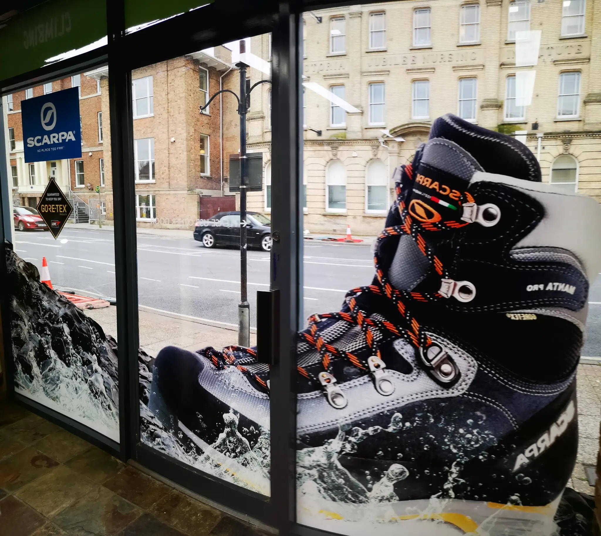 A large shop window graphic of a boot in a store window.
