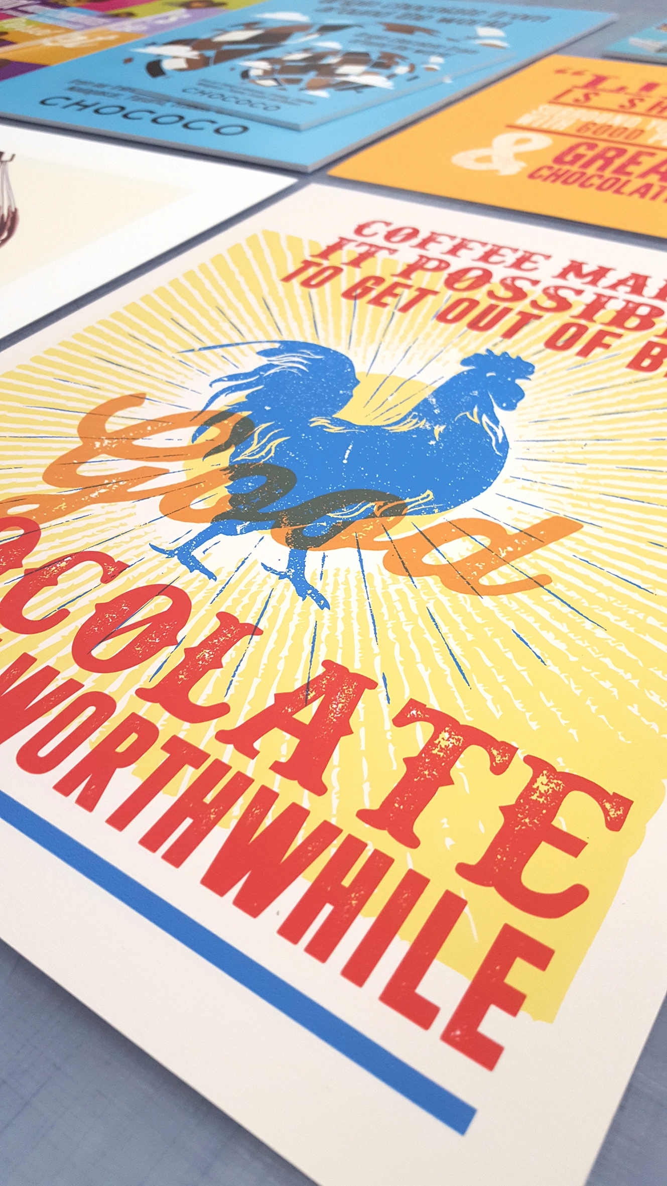 Low-angle shot of a retro print featuring a blue rooster and text reading 'Coffee makes it possible to get out of bed... and good chocolate makes it worthwhile.'