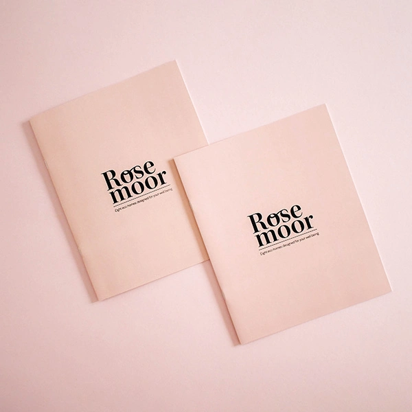 Two digitally printed brochures on a pink background.