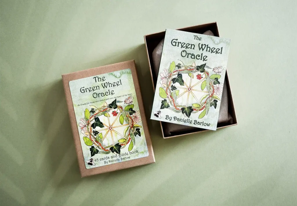 A package created for the green wheel oracle containing 45 cards and guide book, all printed and packaged in-house at Ashley house.