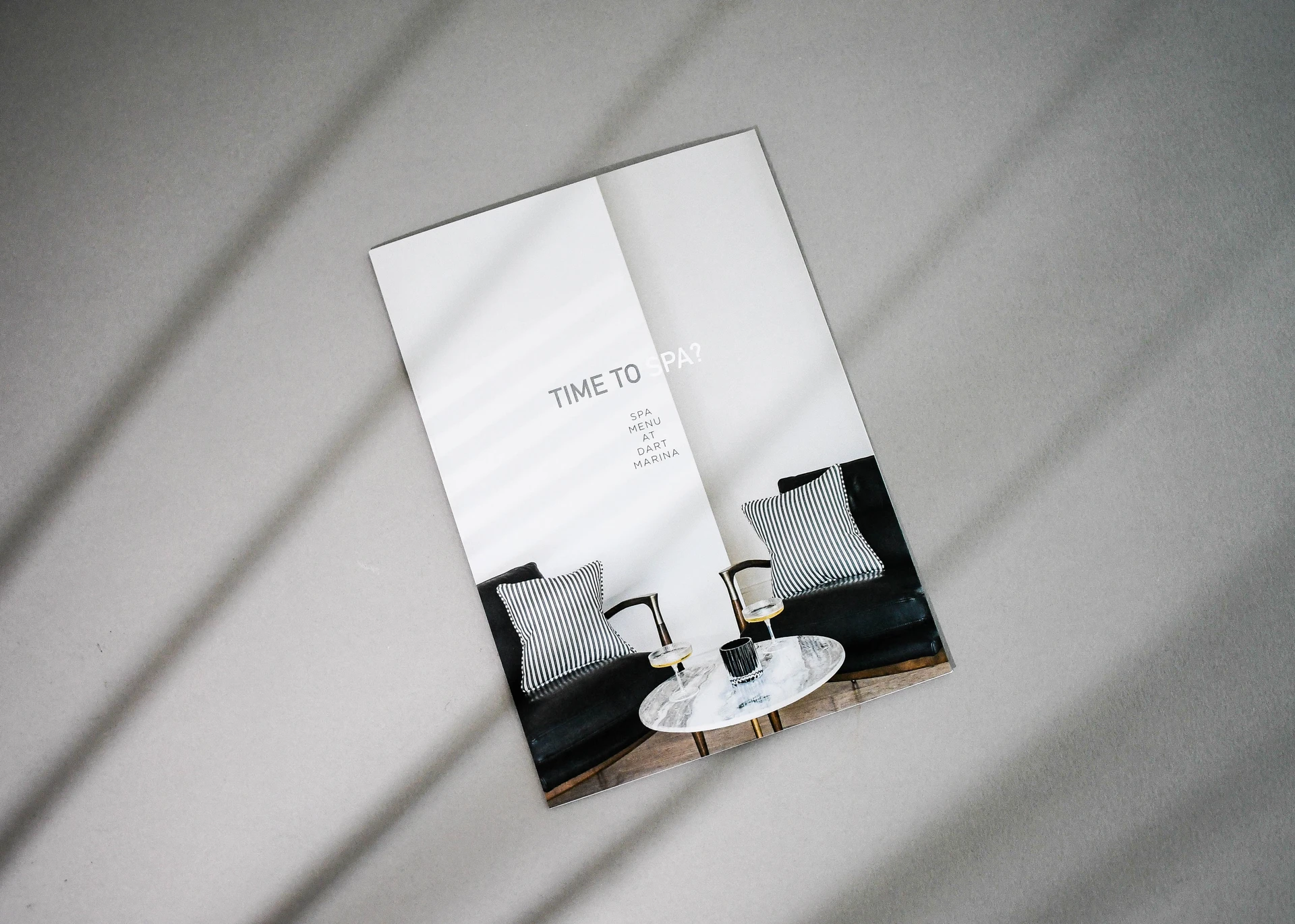 Minimal folded spa menu leaflet featuring a modern interior photograph on the front cover