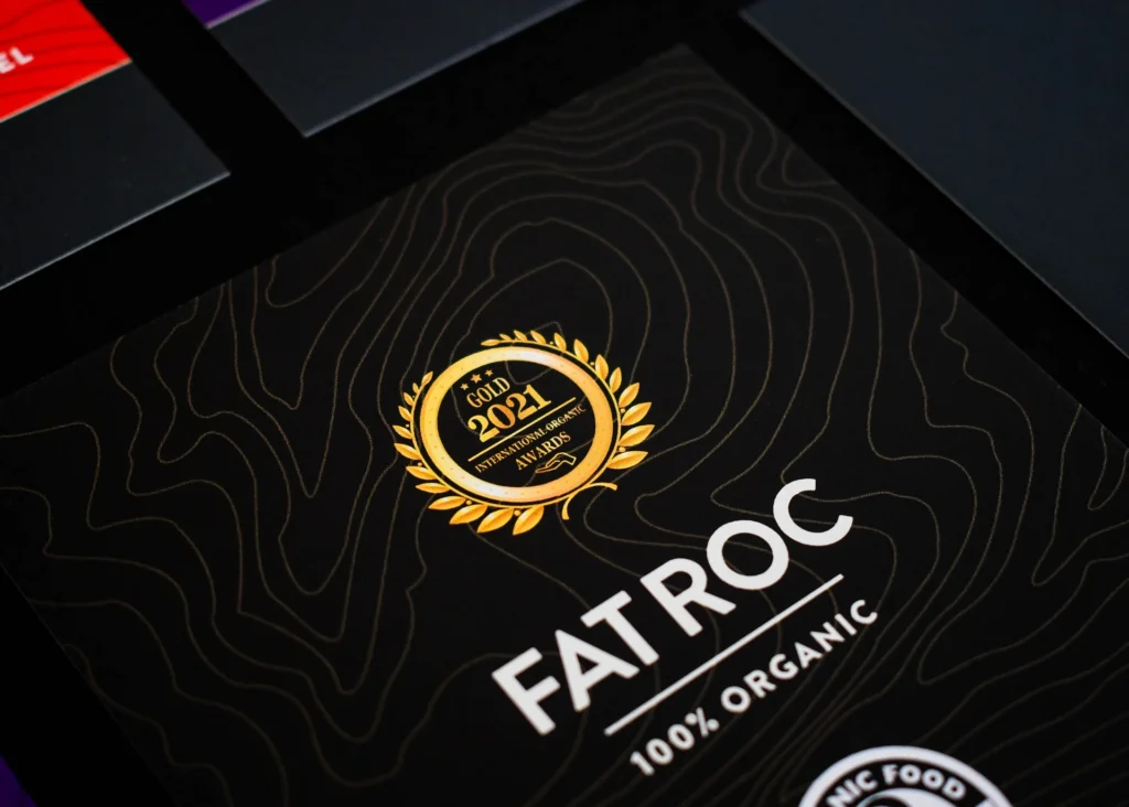 Black promotional flyer featuring a gold organic food award emblem and premium printed finish