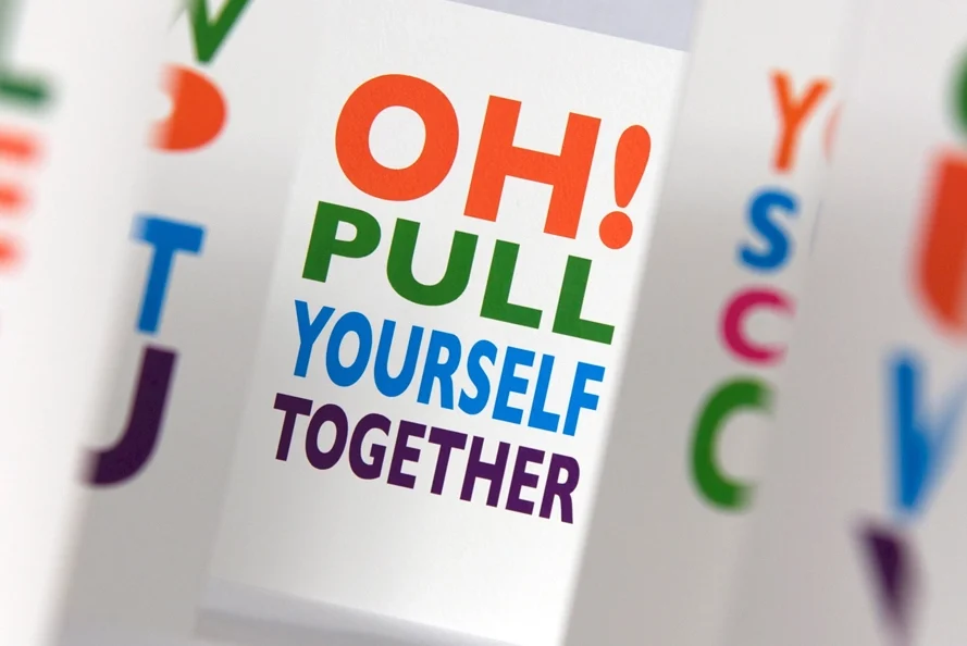 Printed cards featuring large multicoloured typography and bold motivational messages on white paper.