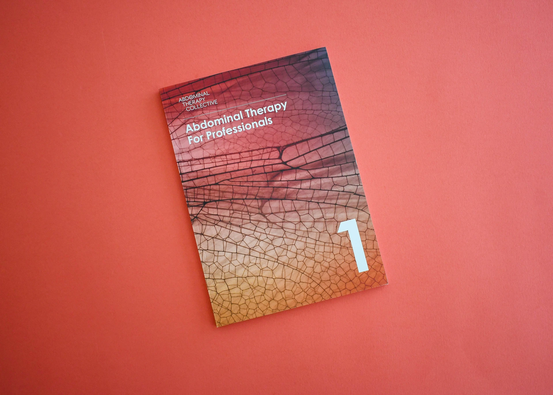 Bound handbook with a dragonfly wing photograph printed full bleed across the cover.