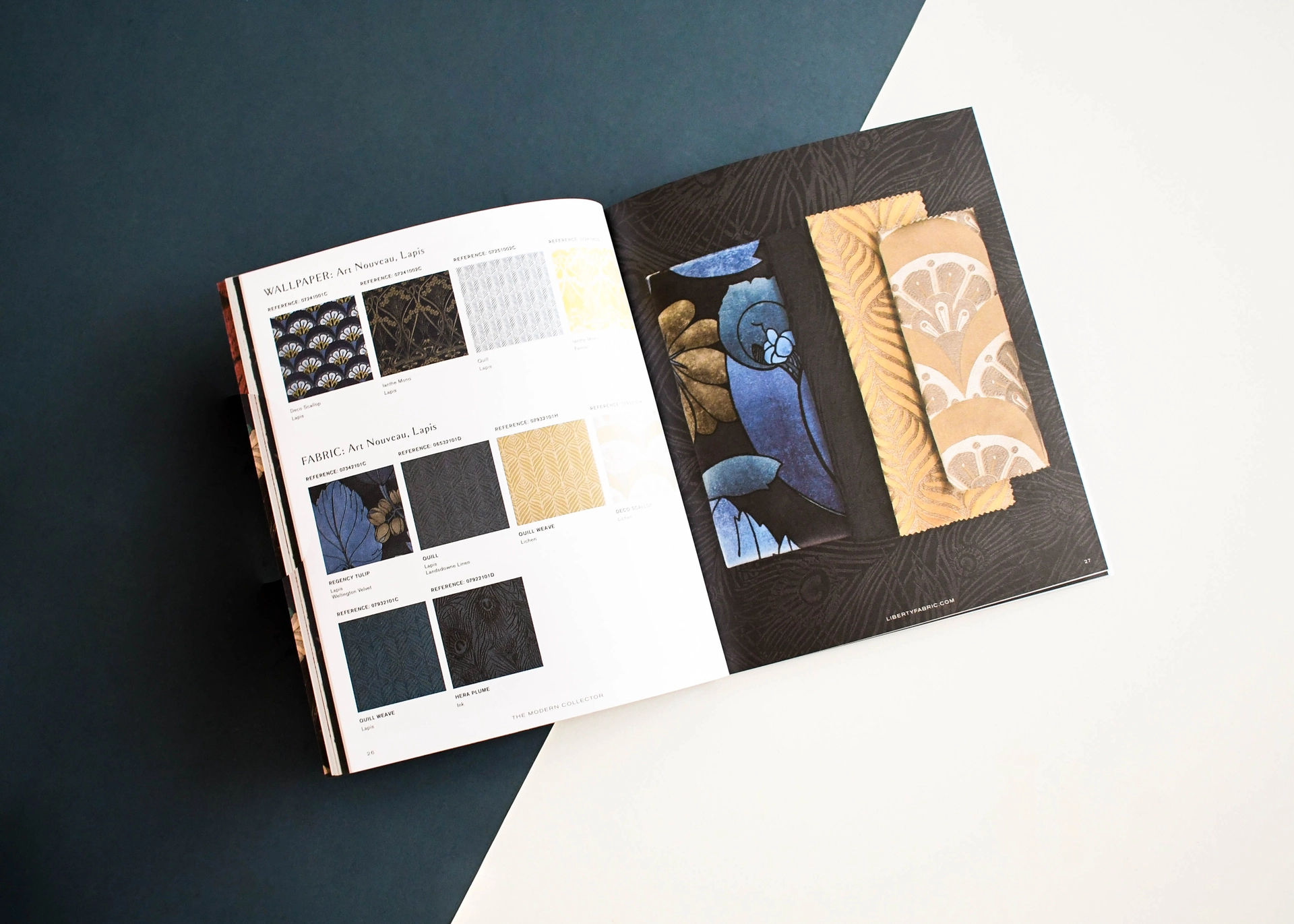 Fabric and wallpaper sample book open on a swatch page with real fabric samples tipped in.