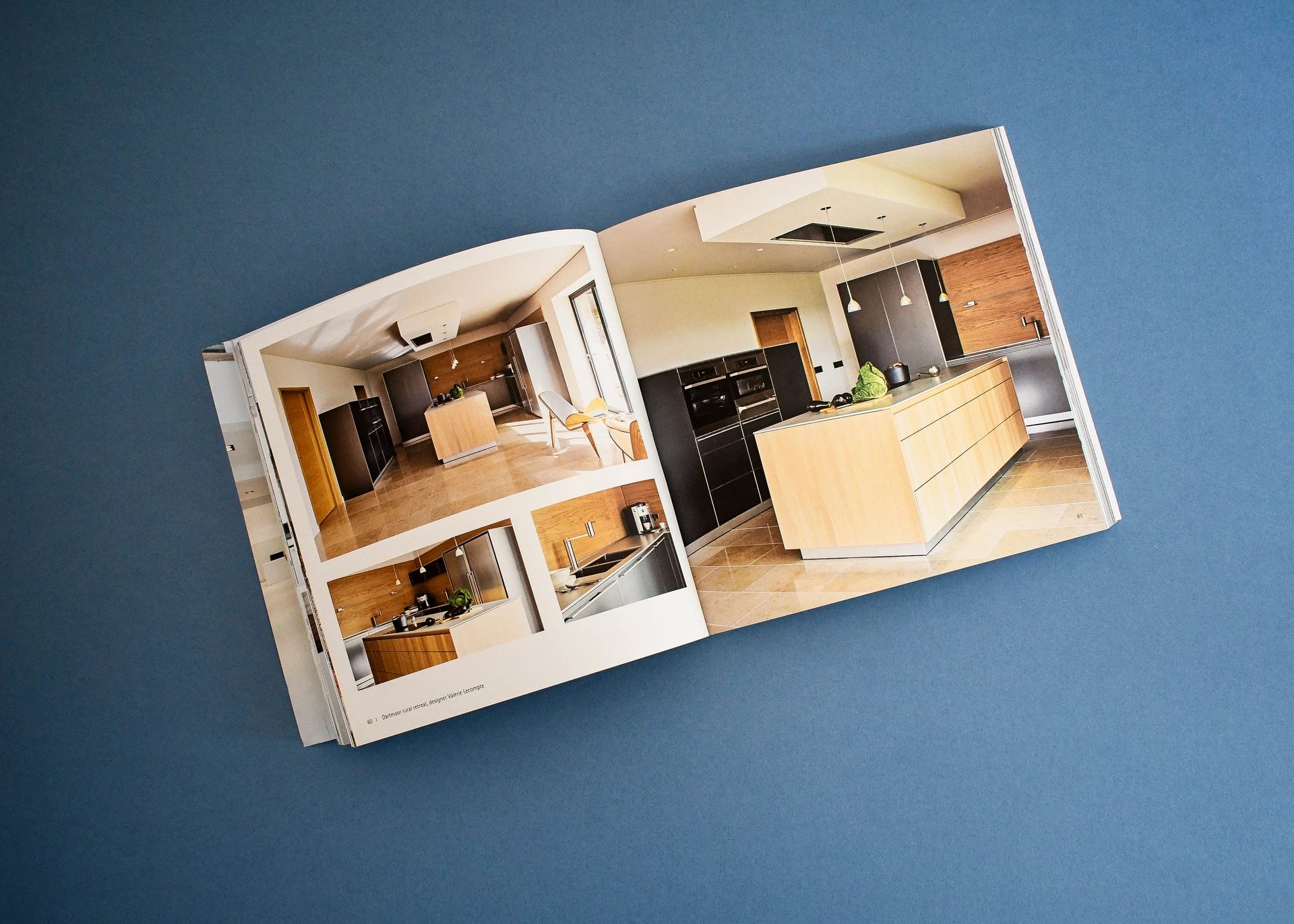 Landscape catalogue open on a full page kitchen photograph running across the spread.