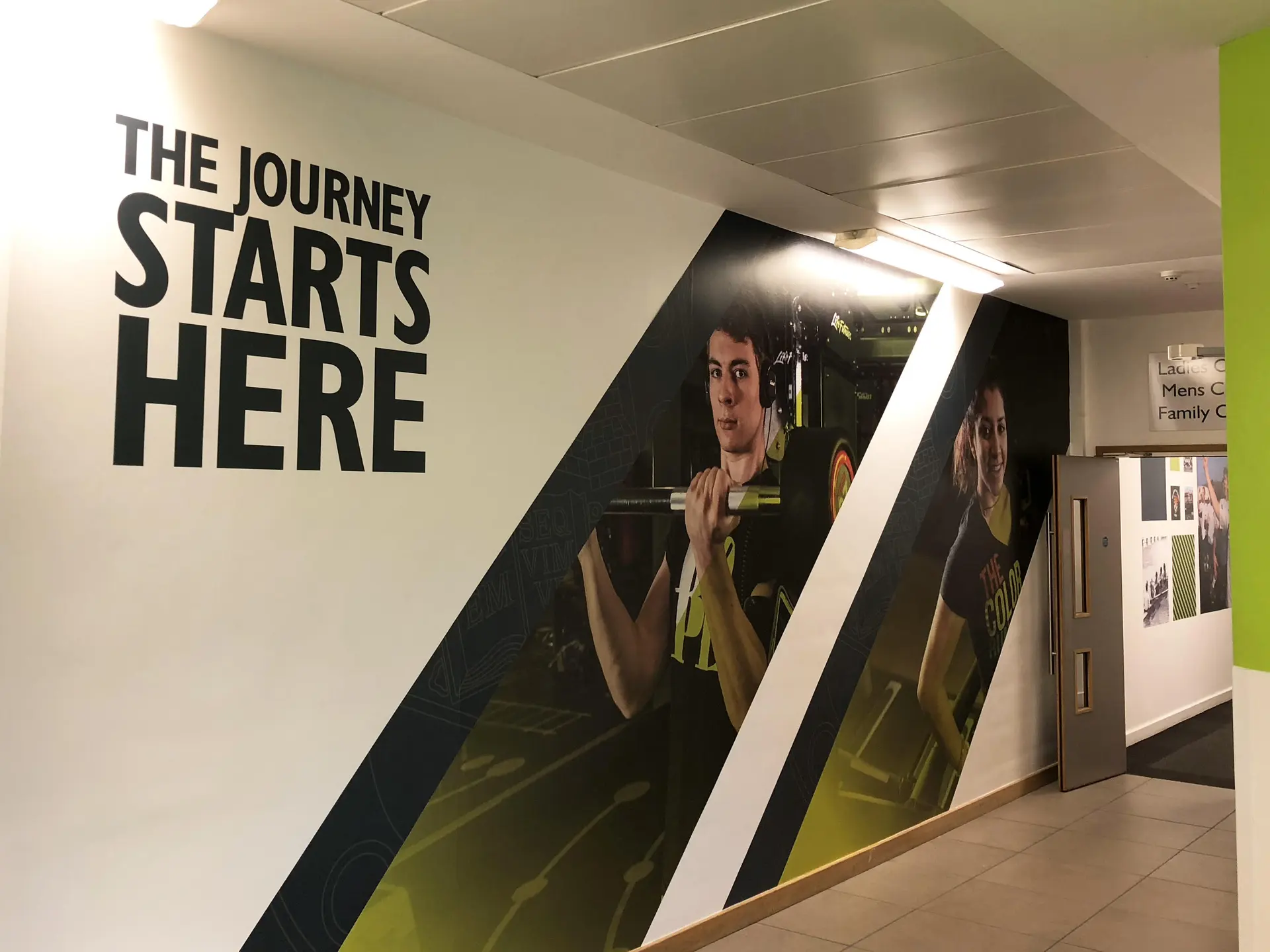 Large format wall graphics featuring fitness imagery in an indoor gym