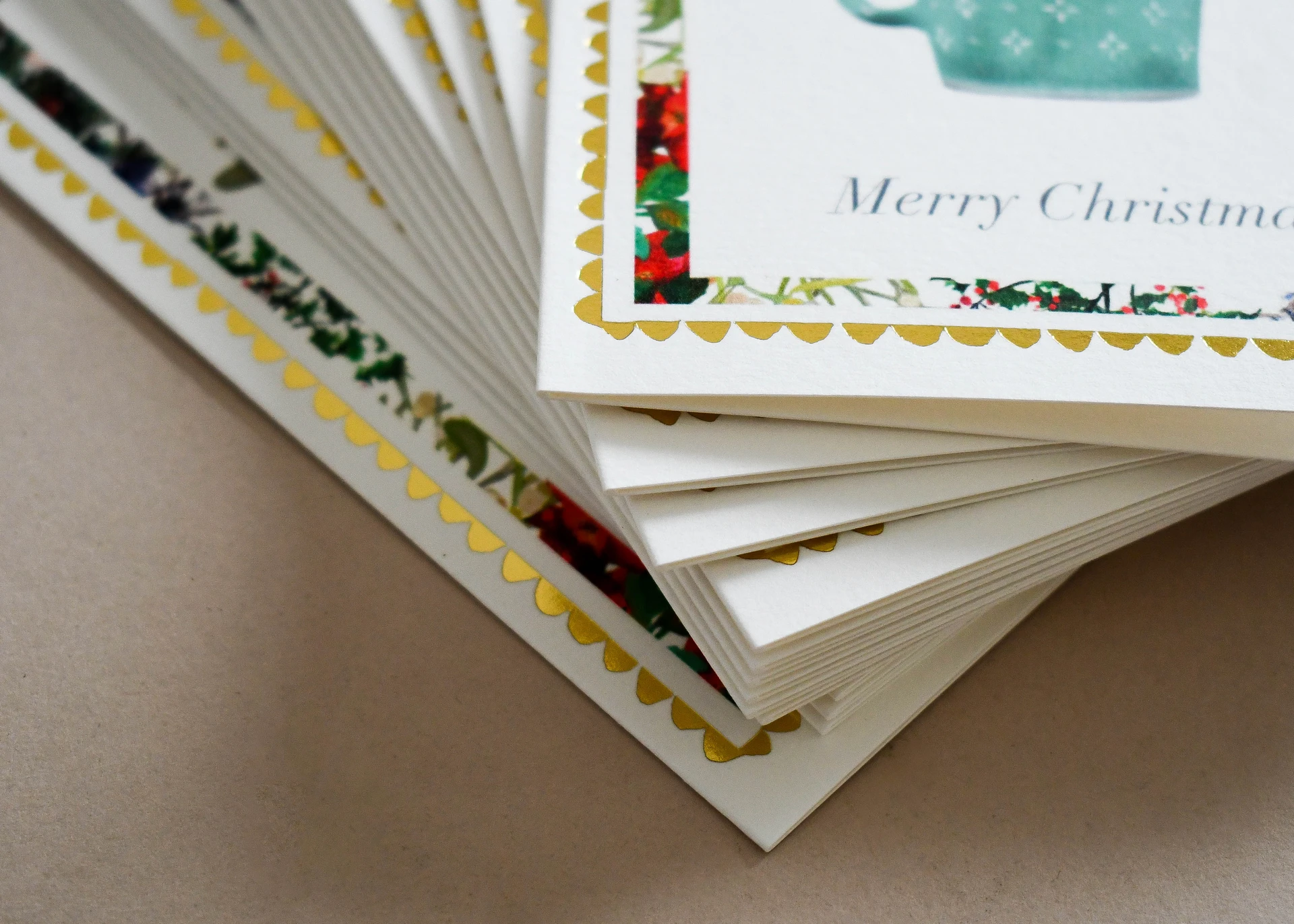 Close-up of gold foil scalloped borders across a fanned stack of cards.