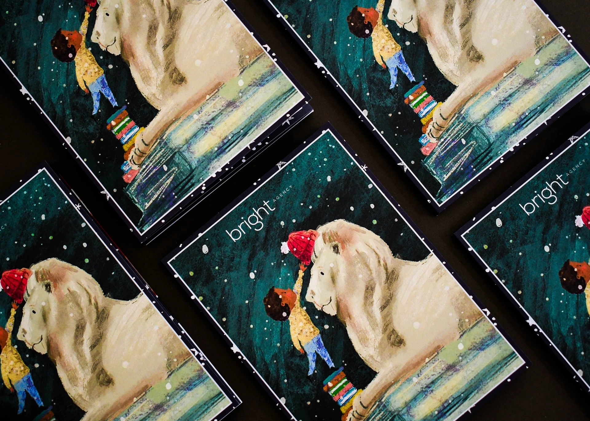 Christmas cards laid face up in rows, each printed with a company logo above the illustration.